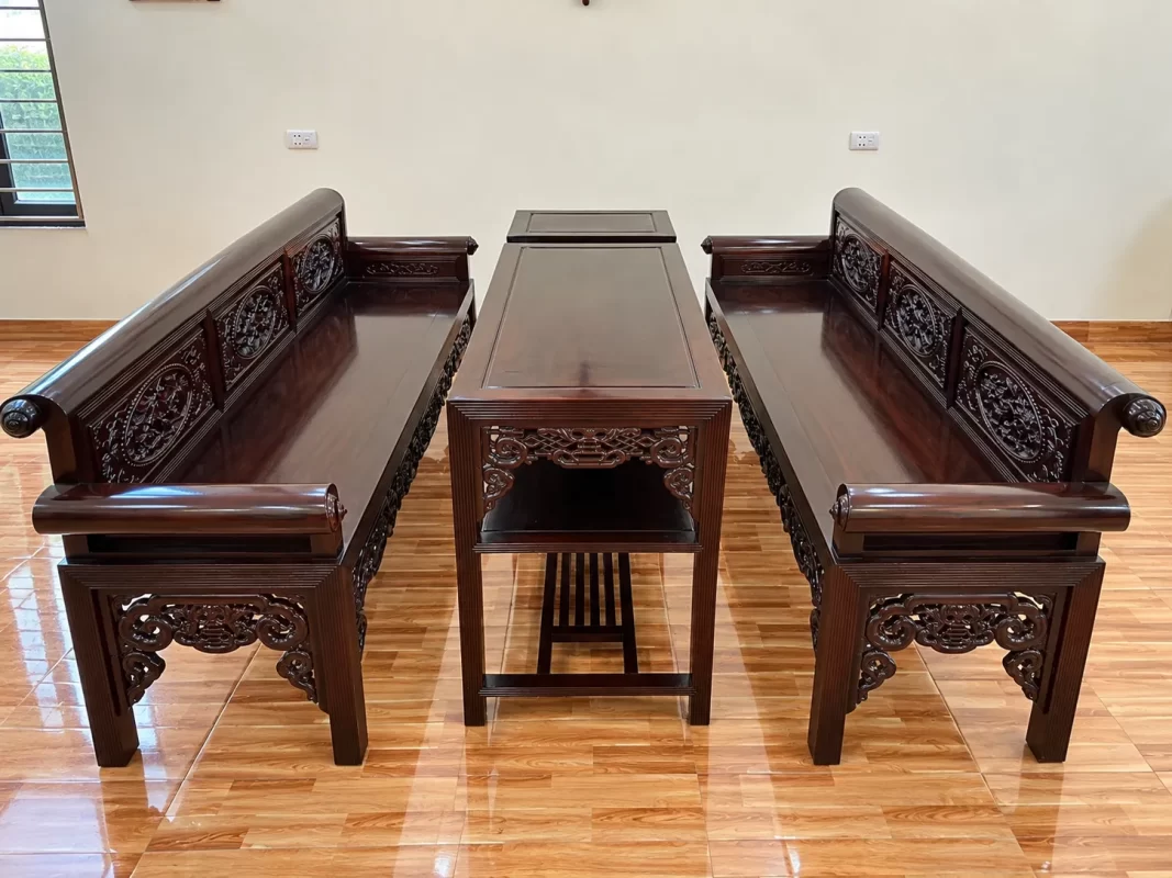 Bộ trường kỷ gỗ đục Tứ Quý 3 món gồm hai ghế trường dài và một bàn trà, phù hợp với phòng khách truyền thống.